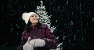 woman outdoors enjoying a snowy Christmas