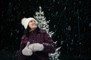 woman outdoors enjoying a snowy Christmas