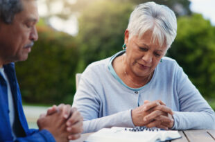 Old couple praying, planning
