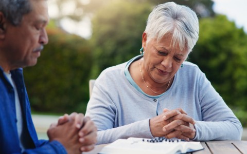 Old couple praying, planning