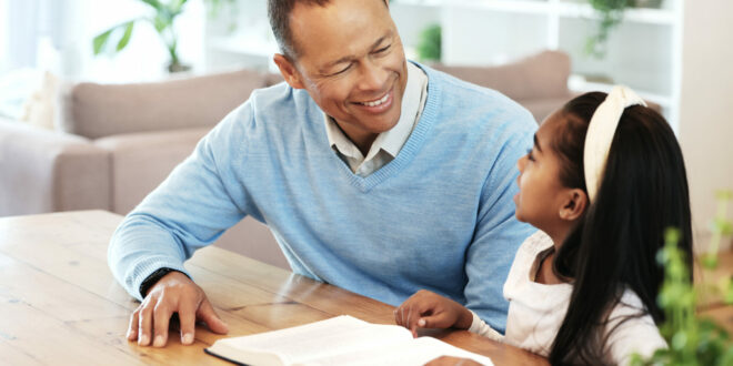 Father teaching Bible to daughter